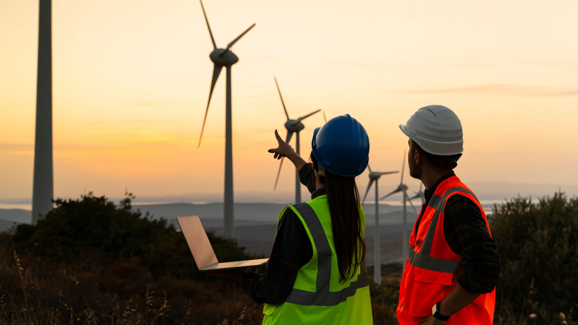 Young engineers looking at the wind turbines