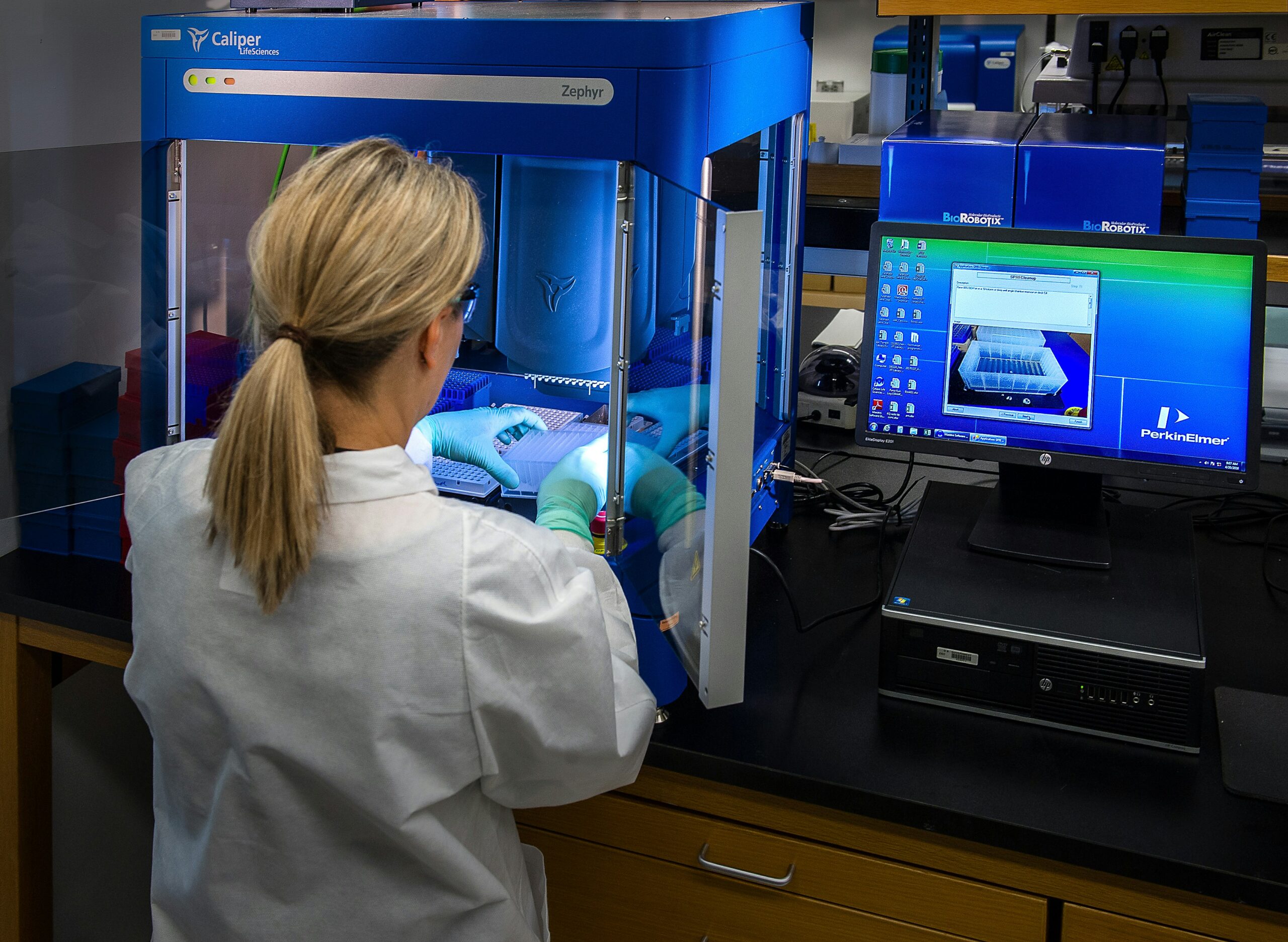 woman-in-white-shirt-standing-in-front-of-computer in the lab