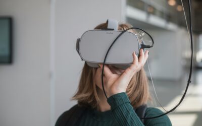 woman-in-black-sweater-holding-white-and-black-vr-goggles