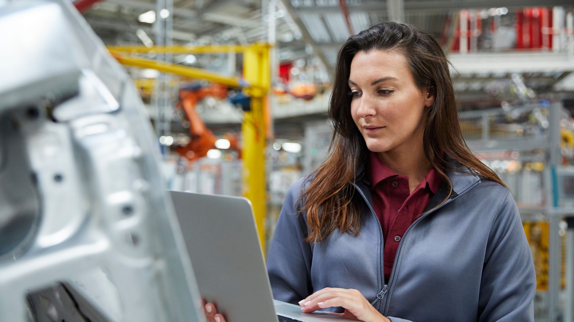 Young engineer using a laptop at the manufacturing line