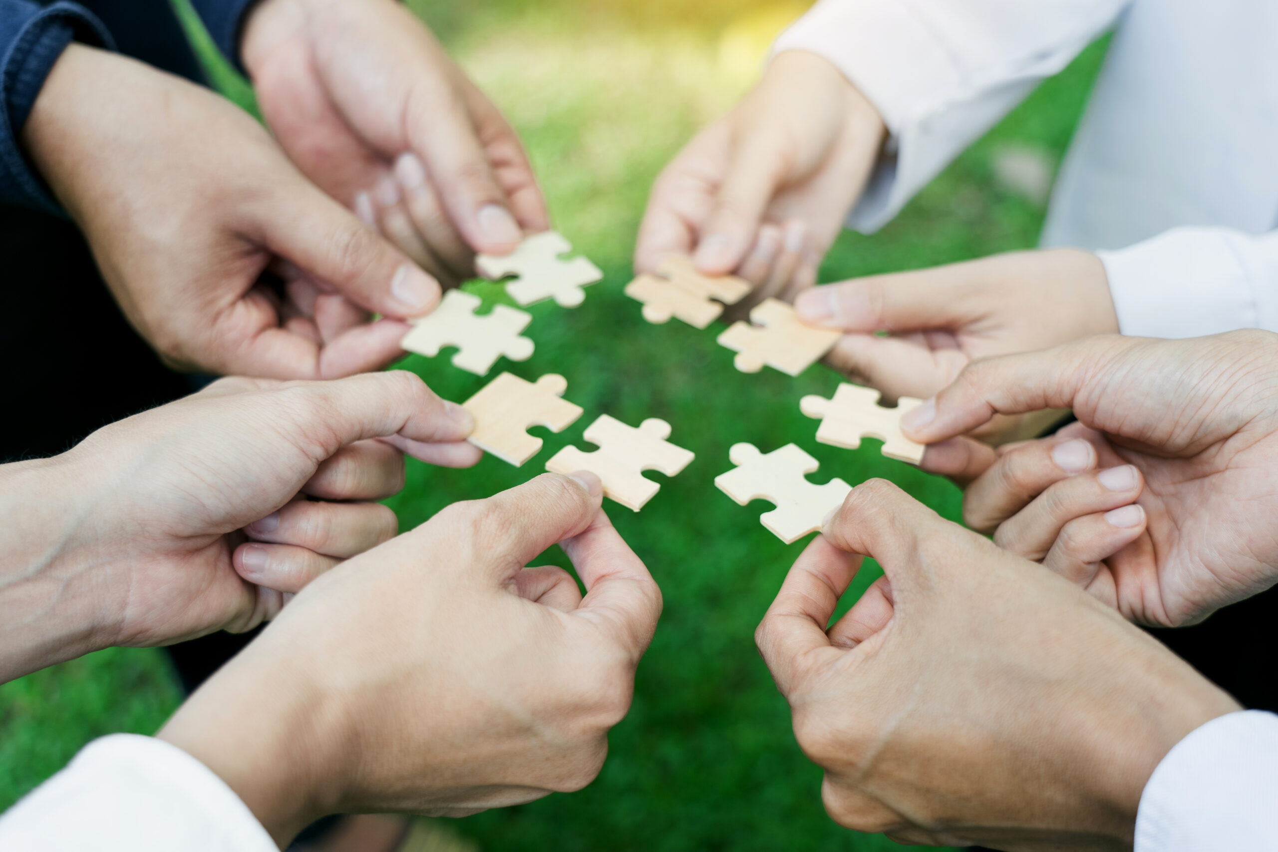 group of business people assembling jigsaw puzzle. The concept of cooperation, teamwork, help and support in business.