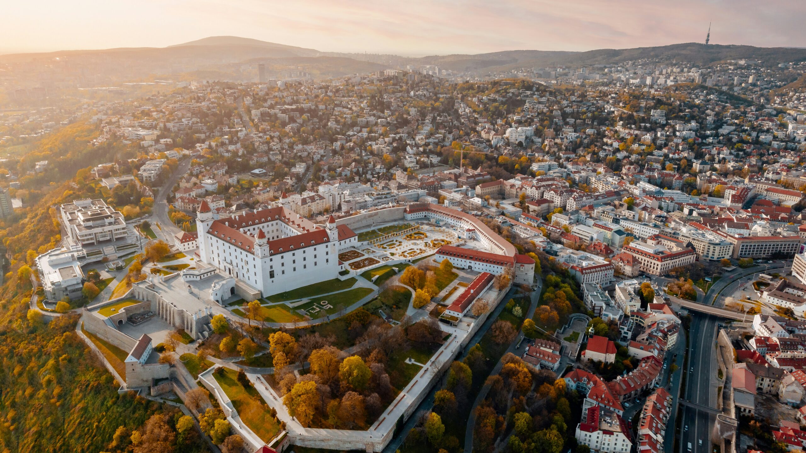 Aerial view of Bratislava, Slovakia, during the day, with the Baroque castle in the foreground.