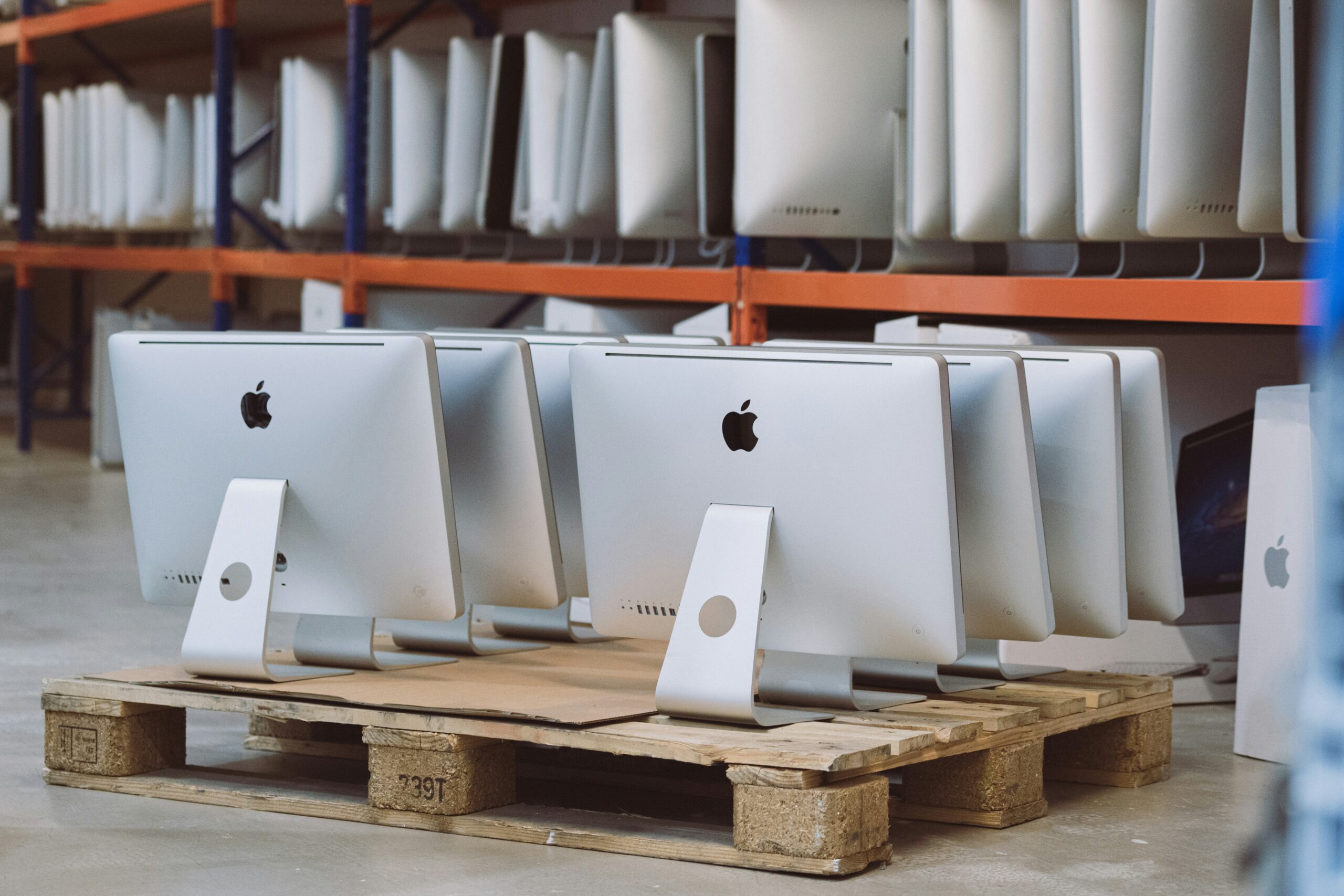 a-row-of-apple-computers-sitting-on-pallets-in-a-store