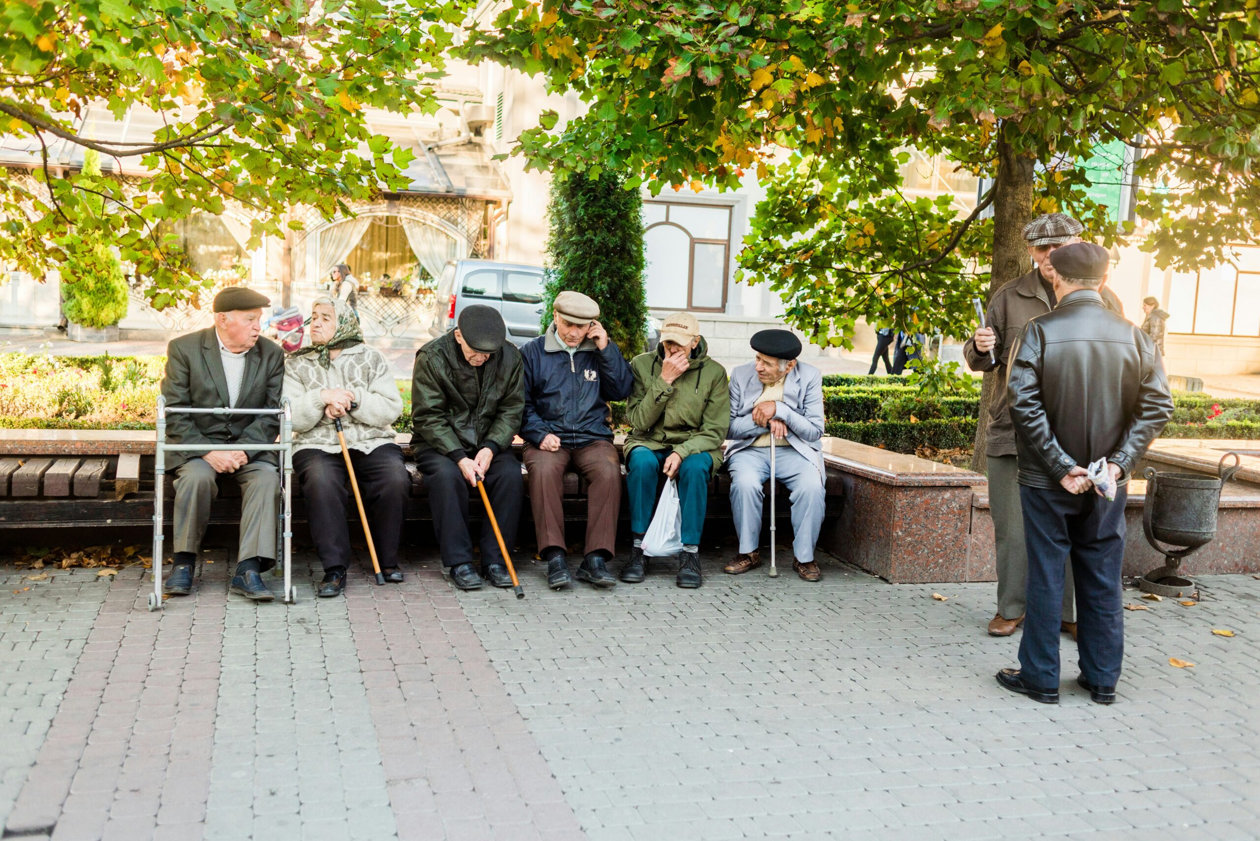 a-group-of-people-sitting-next-to-each-other-on-a-bench