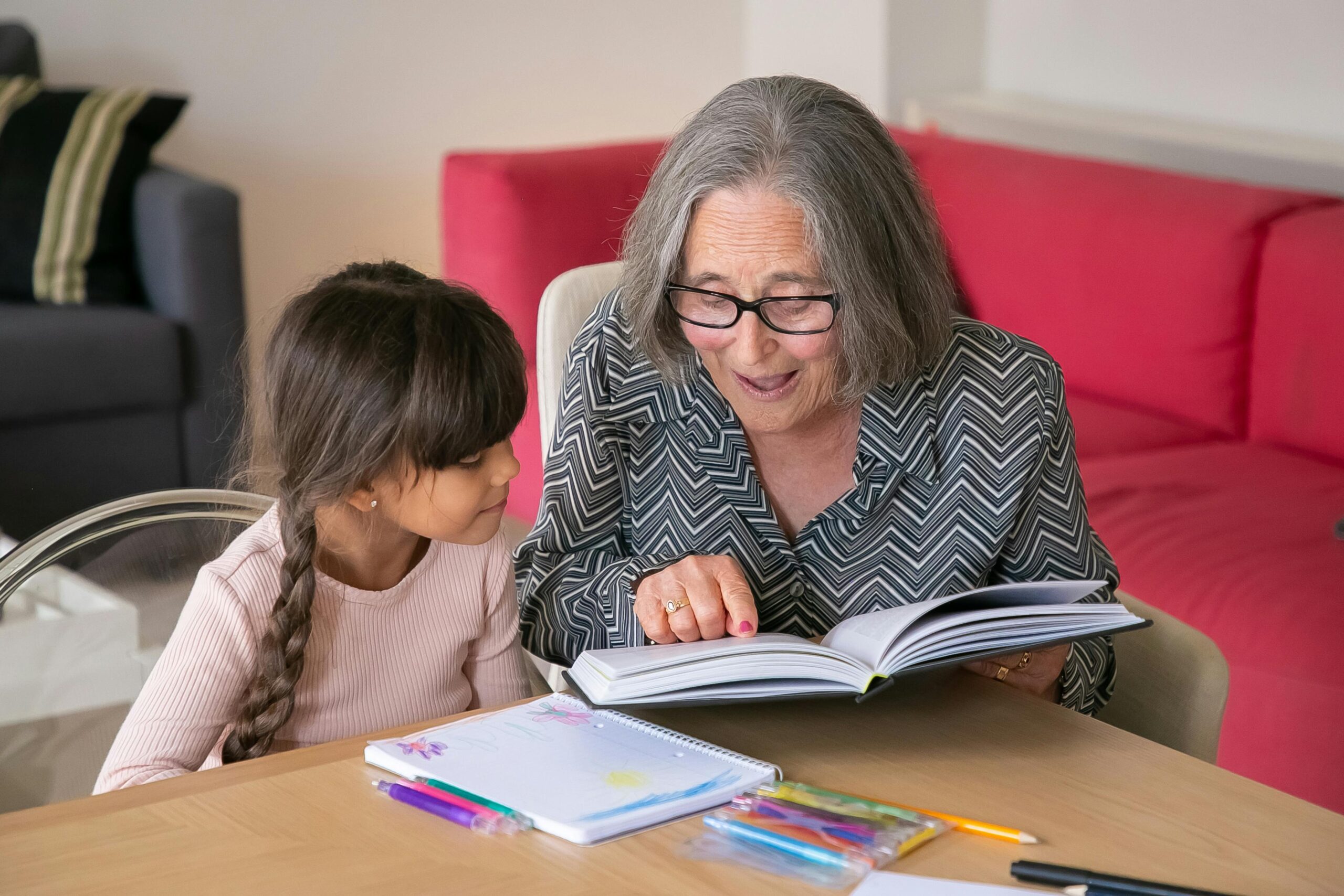 Older woman showing a book to a child