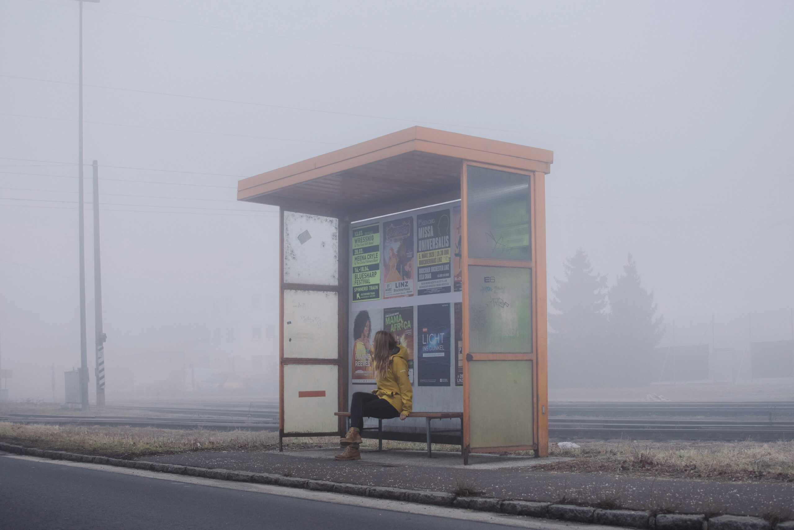 Woman on the bus stop in the rural area