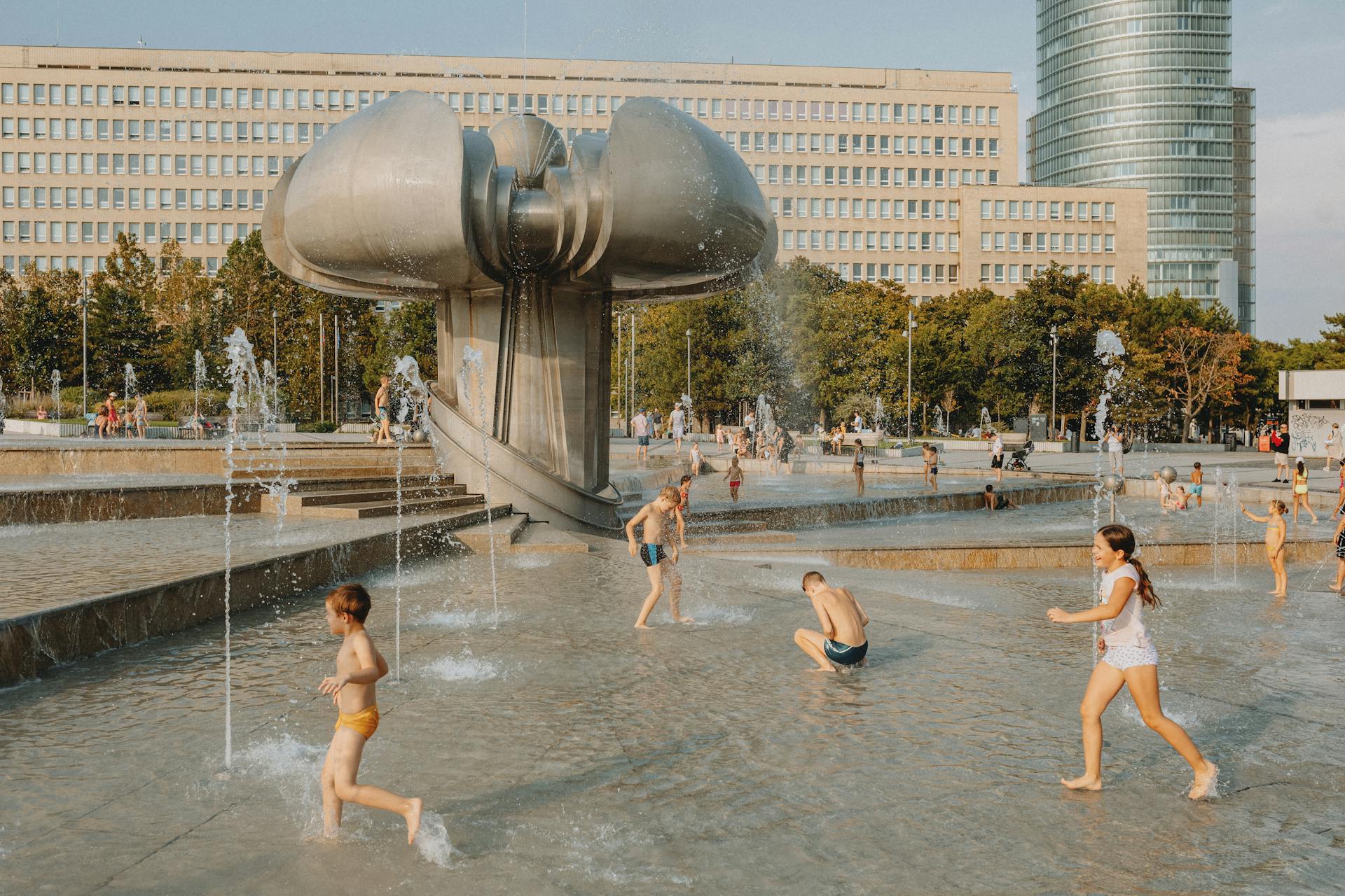 Kids playing in the fountain in summer