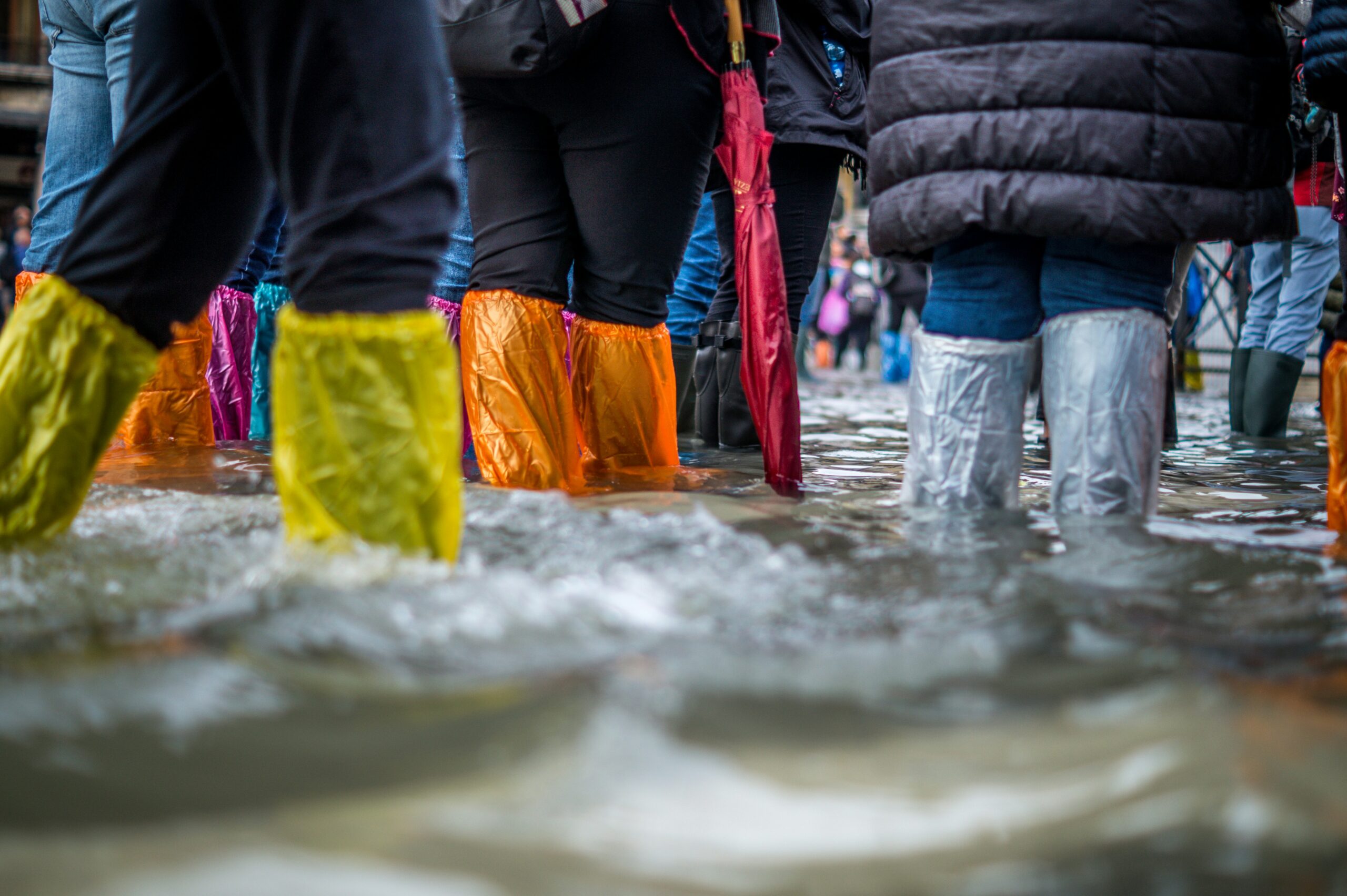 People in wellies walking through flooded street